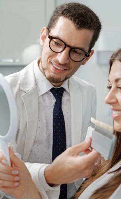 Happy dental patient looking in mirror