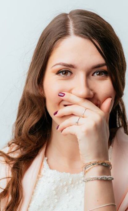 Smiling woman covering her mouth