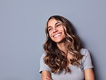 happy woman smiling in front of gray background