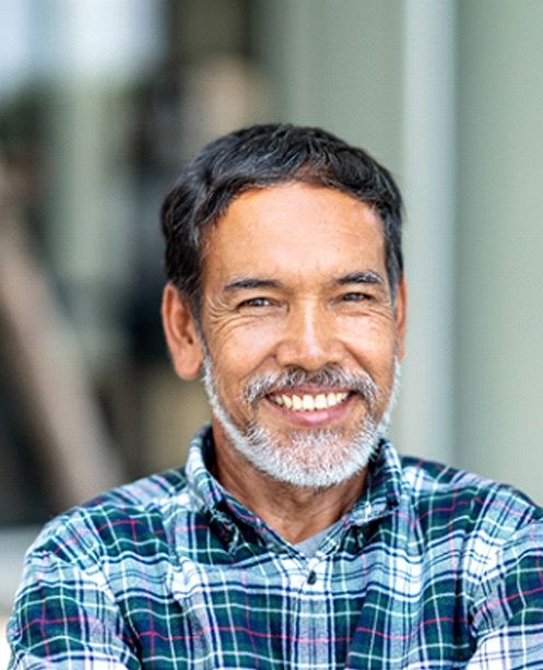 Man smiling with dental crown in Denver