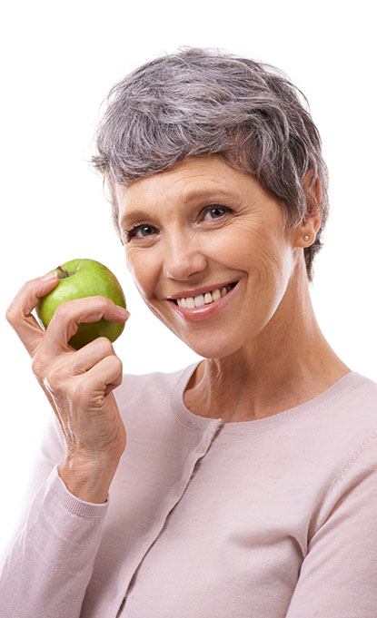 smiling woman holding a green apple