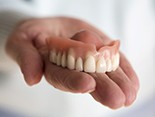 Upper denture in palm of hand
