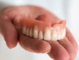 patient holding dentures in hand