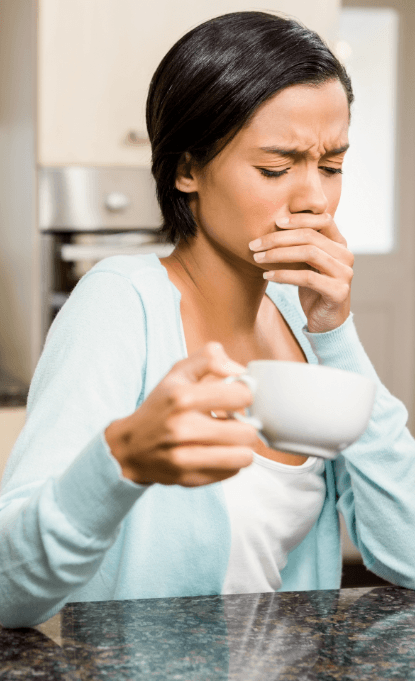 Woman in need of emergency dentistry covering mouth in pain