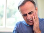 man holding jaw during dental emergency in Denver