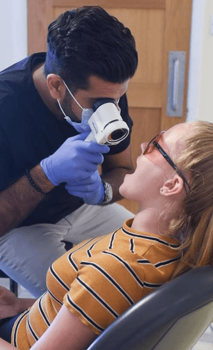Dental team member performing oral cancer screening