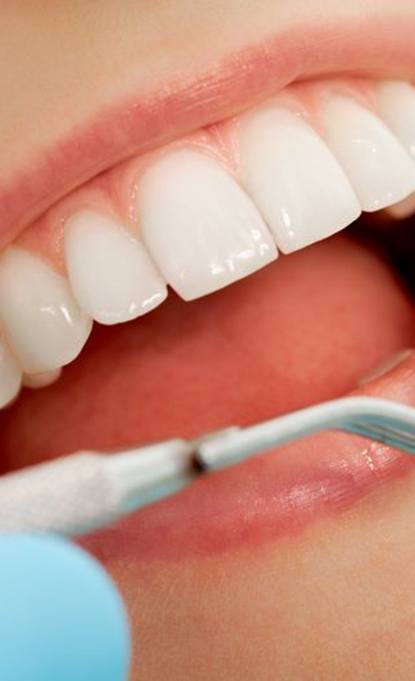 Close-up of woman’s teeth and dental mirror