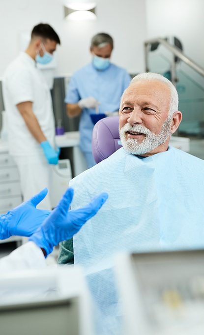 happy man talking to dentist about dental implants in Denver