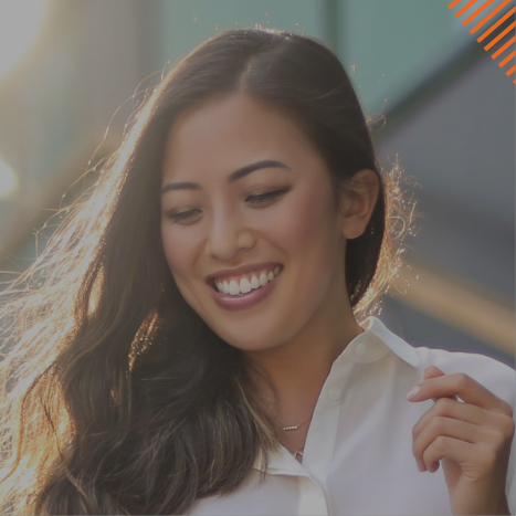 Woman in white collared shirt smiling while looking down