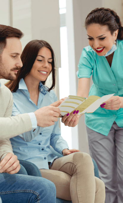 Dental team member giving patients dental insurance forms