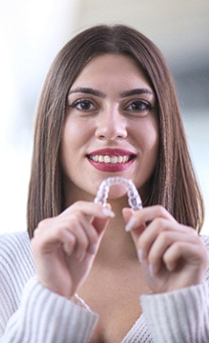 Woman holding Invisalign in Denver