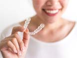 person holding an Invisalign aligner