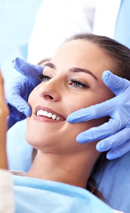 dental patient admiring her smile in a mirror