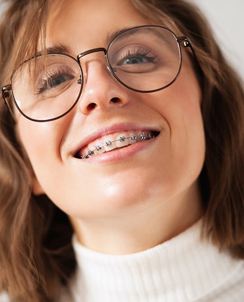 patient smiling after getting traditional braces in Denver