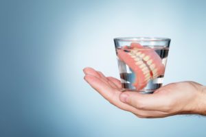 dentures being placed in water over night 